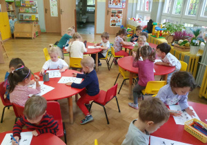 Dzień Kundelka - dzieci siedzą przy stolikach z kartami pracy i łączą ze sobą takie same pieski