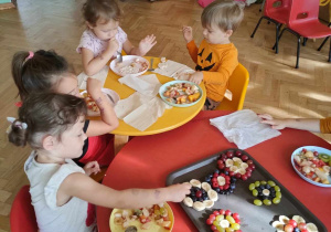 Dzieci siedzą przy stolikach i wykonują obraz z owoców Kandinsky - Abstrakcja