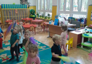 Dzieci tańczą do jesiennej muzyki z kolorowymi chustami