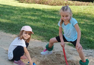Dwie dziewczynki bawią się w piaskownicy