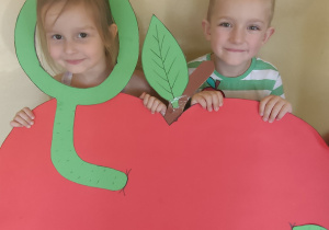 Chłopiec i dziewczynka w fotobudce w kształcie jabłka