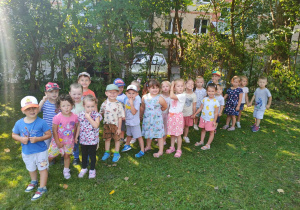 Dzieci w ogrodzie przedszkolnym stoją w parach