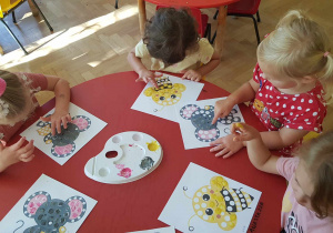Dzień kropki - dzieci siedzą przy stolikach i stemplują palcami kropki na obrazkach
