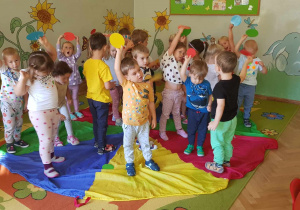 Dzień kropki - dzieci stoją na chuście animacyjnej z kolorowymi kółkami