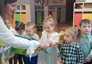 Pani Dyrektor pasuje po kolei dzieci na Przedszkolaków dotykając każdego w ramię magicznym ołówkiem