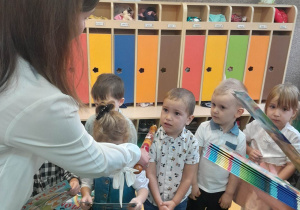 Pani Dyrektor pasuje po kolei dzieci na Przedszkolaków dotykając każdego w ramię magicznym ołówkiem