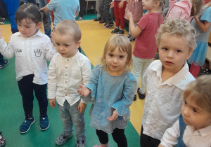 Dzieci ustawione w kole tańczą do piosenki