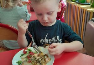 Chłopczyk je makaron w warzywami