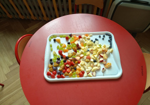 Na stoliku stoi jedna z przygotowanych do warsztatów tac z pokrojonymi owocami