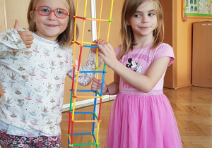 Dziewczynki prezentują budowlę z elementów do łączenia
