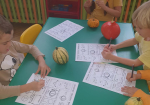 Dzieci wykonują kartę badawczą o dyni