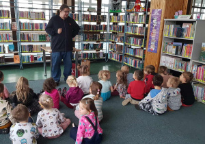 Warsztaty w bibliotece - dzieci słuchają jak pan bibliotekarz opowiada o misiach