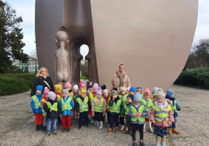 Dzieci pozują do zdjęcia pod Pomnikiem Pękniętego Serca w Parku Szarych Szeregów