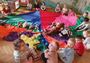 Dzień Pluszowego Misia - dzieci siedzą wkoło chusty animacyjnej
