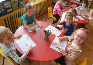 Dzień Pluszowego Misia - dzieci siedzą przy stolikach i kolorują postać misia