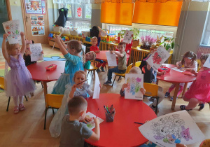 Dzień Postaci z Bajek - dzieci siedzą przy stolikach i kolorują ulubione postacie bajkowe