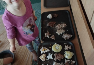 Sensoplastyka - dziewczynka stoi obok tacy ciastek wykonanych przez dzieci