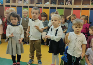 Dzieci ubrane w białe bluzki stoją obok siebie