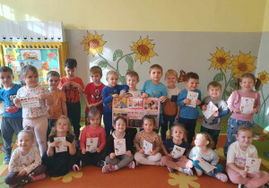 Grupa dzieci trzymająca w rękach obrazki z prawami dziecka