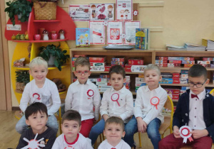 Ośmiu chłopców ubranych w barwy biało czerwone