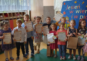 Dzieci stojące z dyplomami w rękach