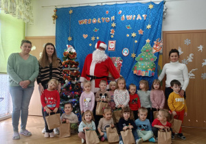 Dzieci wraz z personelem pozują do wspólnego zdjęcia z Mikołajem