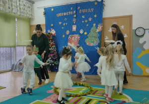 Nauczycielka i pomoc tańczą z dziećmi wspólny taniec
