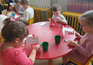Mikołajki - dzieci siedzą przy stolikach i malują obrazki