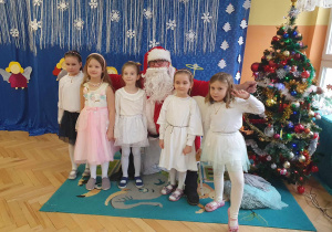 Pięć dziewczynek stojących przed Mikołajem