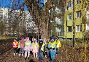 Spacer ulicami osiedla - dzieci pozują do zdjęcia pod drzewem