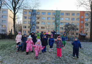Dzieci stoją na górce w ogrodzie przedszkolnym