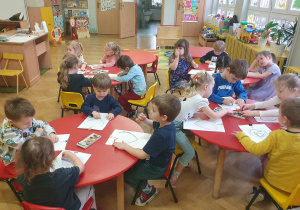 Zabawa sztuką -Op-art, dzieci siedzą przy stolikach i wykonują serduszka