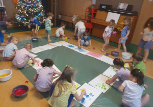 Sensoplastyka - dzieci malują na kartonach z wykorzystaniem jadalnych farb