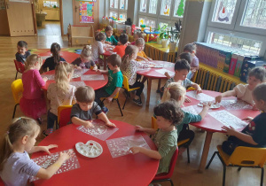 Zabawy sztuką - dzieci siedzą przy stolikach i wykonują zimowe witraże