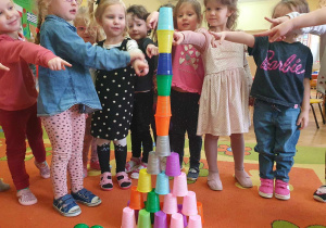 Co potrafią nasze rączki - dziewczynki pokazują wykonaną przez siebie wieżę z kolorowych kubeczków