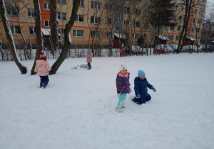 Dzieci biegają po śniegu, robiąc ślady