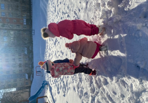 czworo dzieci w kolorowych zimowych ubraniach bawią się na śniegu
