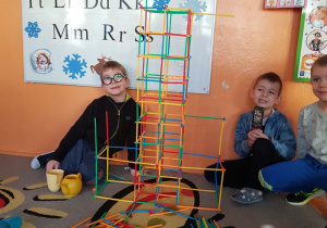 Chłopcy demonstrują budowlę z klocków.