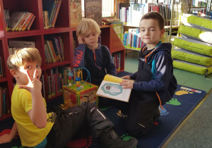 Warsztaty w bibliotece - dzieci oglądają wybrane książki.