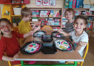 Dzieci siedzą przy stoliku malując rosnącymi farbami