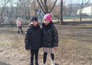 Dwie dziewczynki pozują do zdjęcia w ogrodzie przedszkolnym