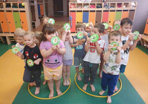 Dzień Dinozaura - dzieci z emblematami dinozaurów bawią się na sali gimnastycznej