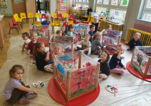 Zabawa sztuką - dzieci siedzą na podłodze i malują farbami na folii