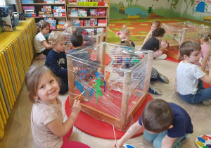 Zabawa sztuką - dzieci siedzą na podłodze i malują farbami na folii, którą owinięte są stoły