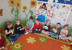 Sztuka - wspólne muzykowanie, dzieci siedzą na dywanie i grają na instrumentach muzycznych