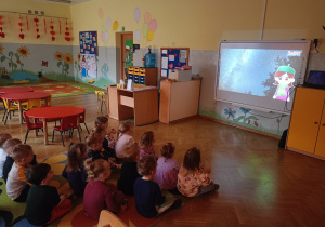 Dzieci oglądają w grupie króliczki film edukacyjny na tablicy interaktywnej,,Kosmos dla dzieci"