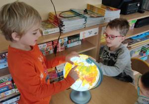 Chłopiec dotyka palcem podświetlany globus