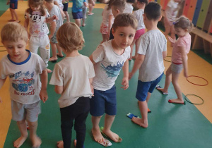 Dzień Kolorowej Skarpetki - dzieci na sali gimnastycznej chowają skarpetki pod stopami