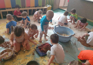 Sensoplastyka - dzieci bawią się na folii malarskiej z wykorzystaniem różnorodnych produktów spożywczych