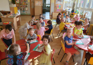 Dzień motyla - dzieci siedzą przy stolikach i kolorują wykonana przez siebie pracę